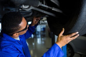 Vida útil de componentes de direção: mecânico inspecionando peças de um veículo