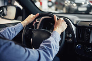 Tipos de direção automotiva: homem ao volante.